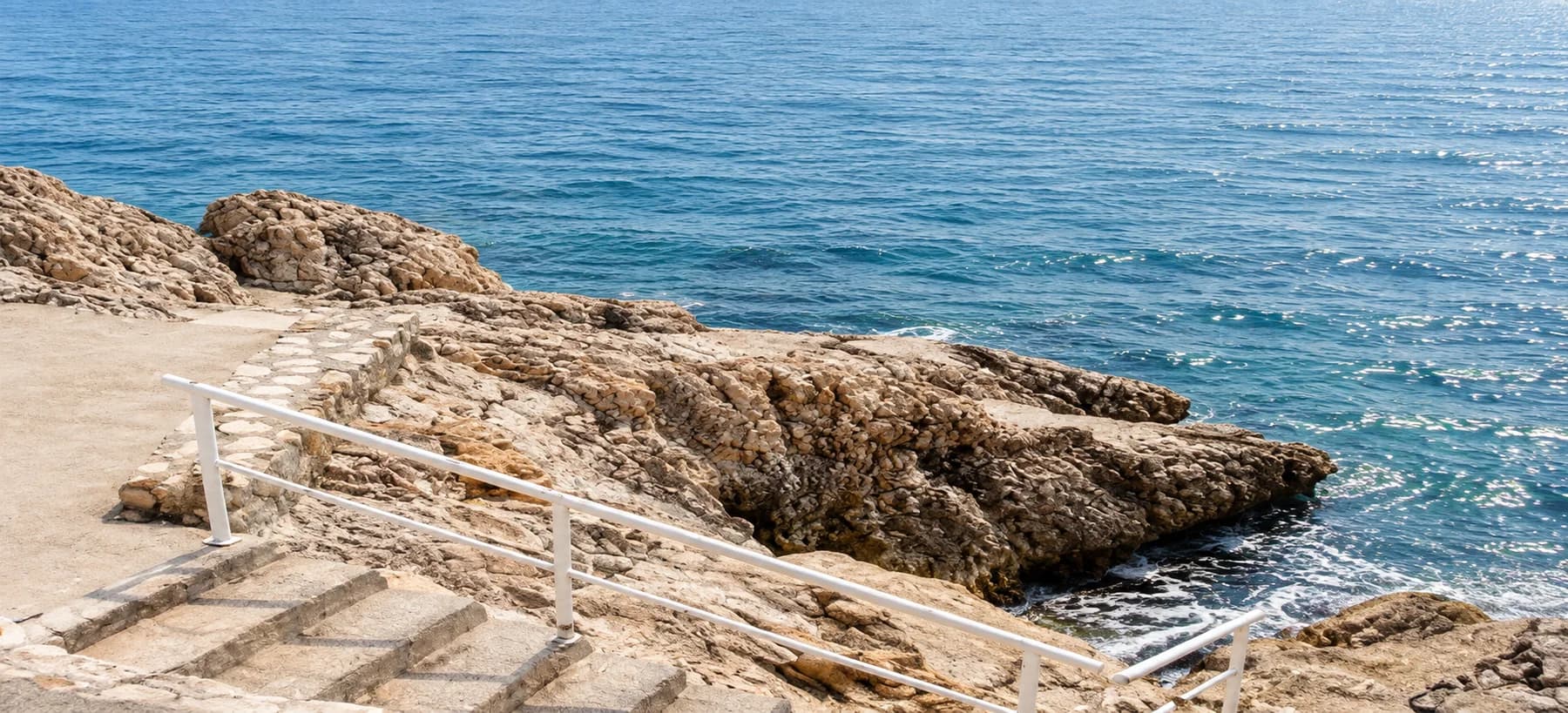 Turquoise sea breaking against pale rocks